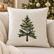 Cream cushion cover with an embroidered green Christmas tree, white snowflakes and green piping on a cream sofa.