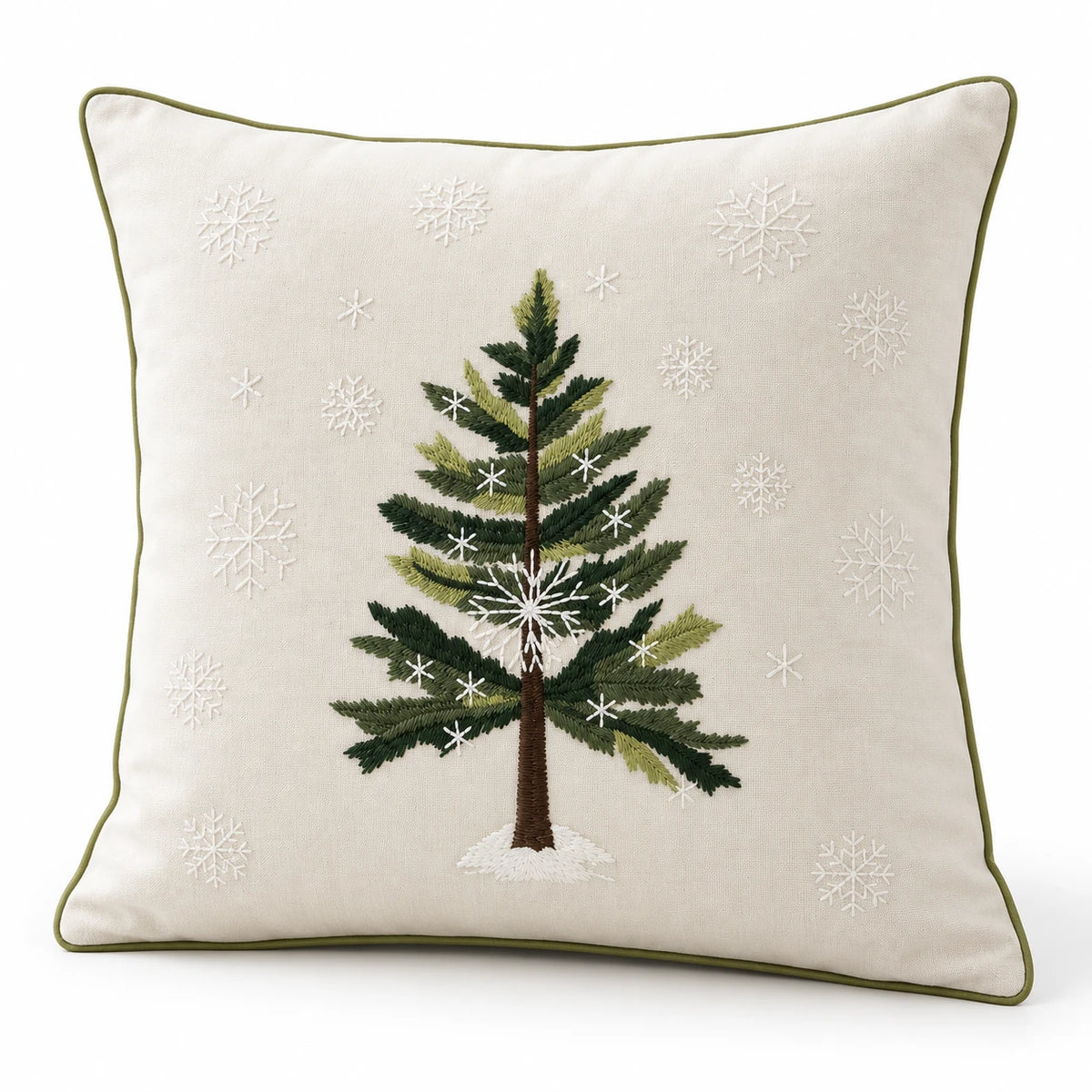 Angled studio view of the cream Christmas cushion cover showing green tree embroidery, white snowflakes and piped edges.
