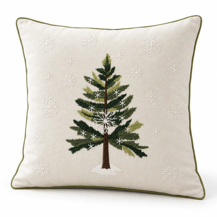 Angled studio view of the cream Christmas cushion cover showing green tree embroidery, white snowflakes and piped edges.