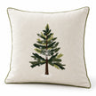 Angled studio view of the cream Christmas cushion cover showing green tree embroidery, white snowflakes and piped edges.