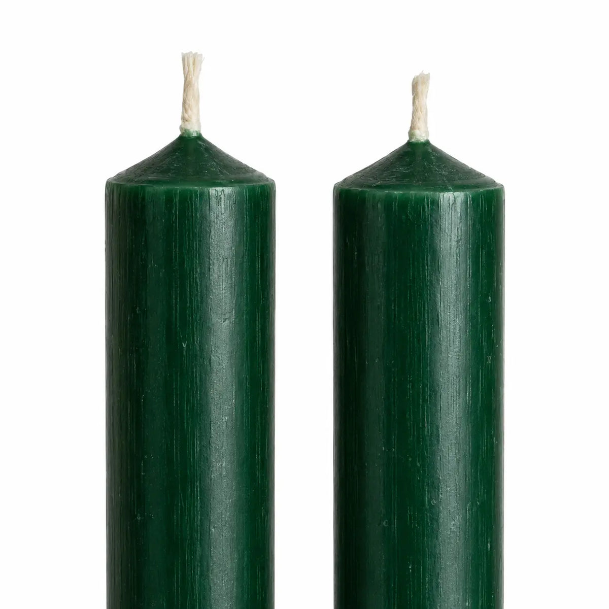 Close-up of the rustic green wax finish and unlit wicks on two dinner candles.