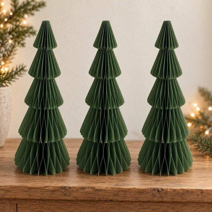 Three matching 30 cm green paper Christmas trees side by side on an oak console.