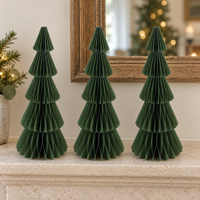 Three matching 30 cm green paper Christmas trees on a pale stone mantel.