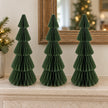 Three matching 30 cm green paper Christmas trees on a pale stone mantel.