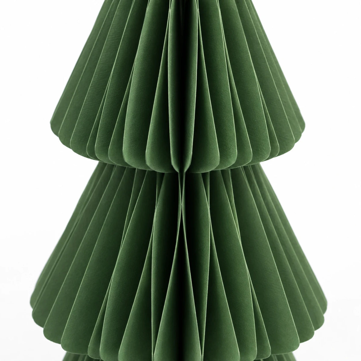 Close-up of the folded green paper and tier edges of a 30 cm Christmas tree.