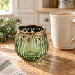 Green ribbed glass tea light candle holder by Originals International Ltd on a kitchen scale