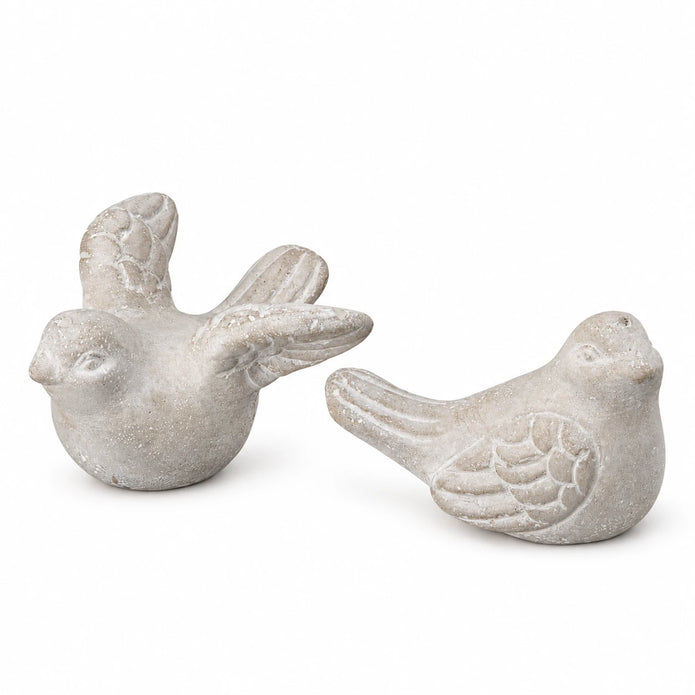 Set of two grey stone bird ornaments on white, one with raised wings and one with folded wings.