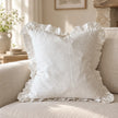Hallie white stonewashed linen ruffled cushion cover styled on an oatmeal sofa