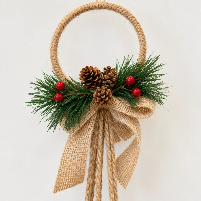 Close-up of the jute-wrapped hoop, hessian bow, pinecone and berry detail.