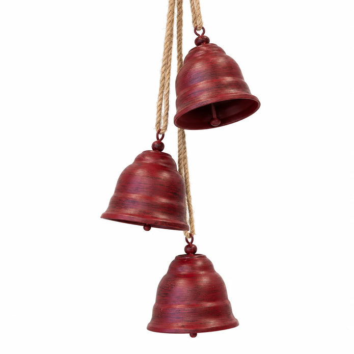 Close-up of three aged red metal bells hanging at staggered heights from natural cords