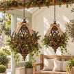 Large and small rusty lattice ball planters styled for Christmas with evergreen foliage, fairy lights and low hessian bows.