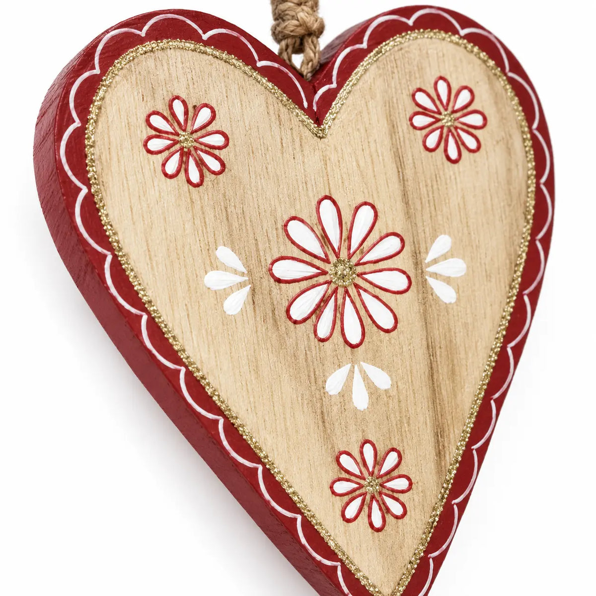 Close-up of red and white floral detailing and wood grain on a hanging heart