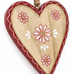 Close-up of red and white floral detailing and wood grain on a hanging heart