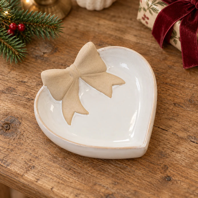 Heart-shaped bow dish lying flat on an oak console with Christmas greenery