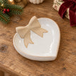 Heart-shaped bow dish lying flat on an oak console with Christmas greenery