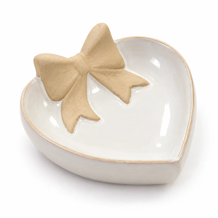 Studio detail of the unglazed beige bow and glossy white heart dish