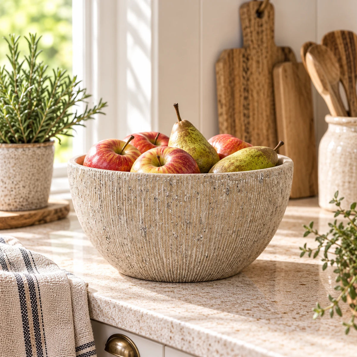 Heritage Stone Fruit Bowl with vertical ribbed stone-effect texture styled with apples and pears in a bright country kitchen; fruit shown for styling only