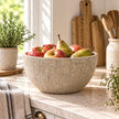 Heritage Stone Fruit Bowl with vertical ribbed stone-effect texture styled with apples and pears in a bright country kitchen; fruit shown for styling only