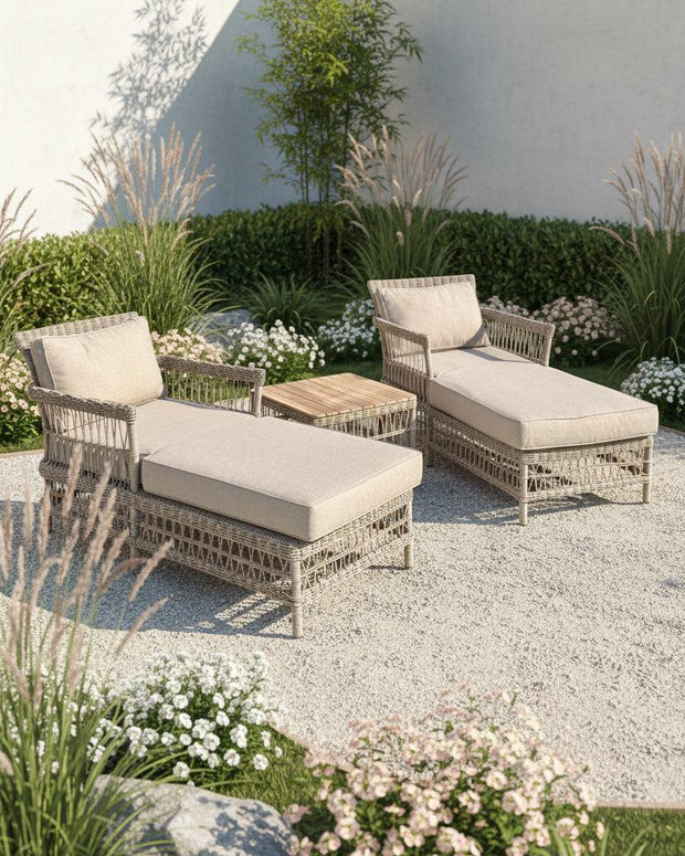 Rattan Provence three-piece outdoor sun lounger set by Hill Interiors with cushioned loungers and a matching side table in a garden setting.