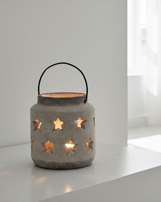 Stone star hurricane lantern for home decor, featuring a rustic design with a glass enclosure and stone star accents.