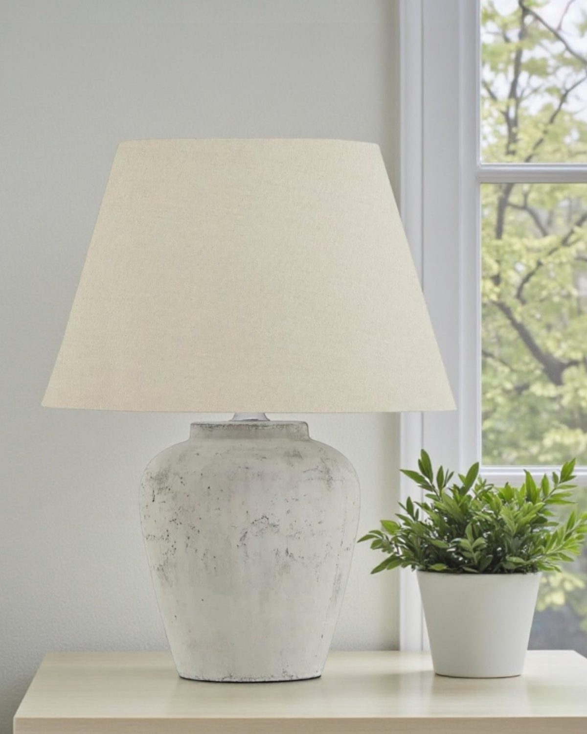 A medium Hill Interiors Amesbury stone lamp with natural round base, 53cm tall, showcasing elegant lighting design.
