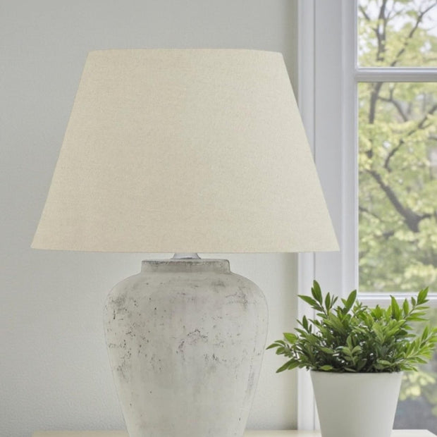 A medium Hill Interiors Amesbury stone lamp with natural round base, 53cm tall, showcasing elegant lighting design.