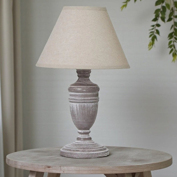 Hill Interiors Metis Compact Urn Lamp with 26cm distressed wood and linen shade, showcasing elegant lighting design.