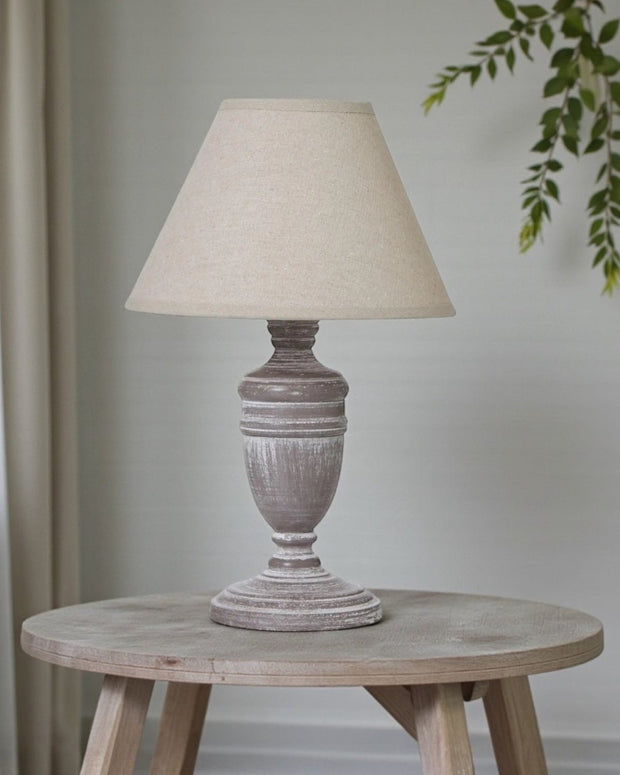 Hill Interiors Metis Compact Urn Lamp with 26cm distressed wood and linen shade, showcasing elegant lighting design.