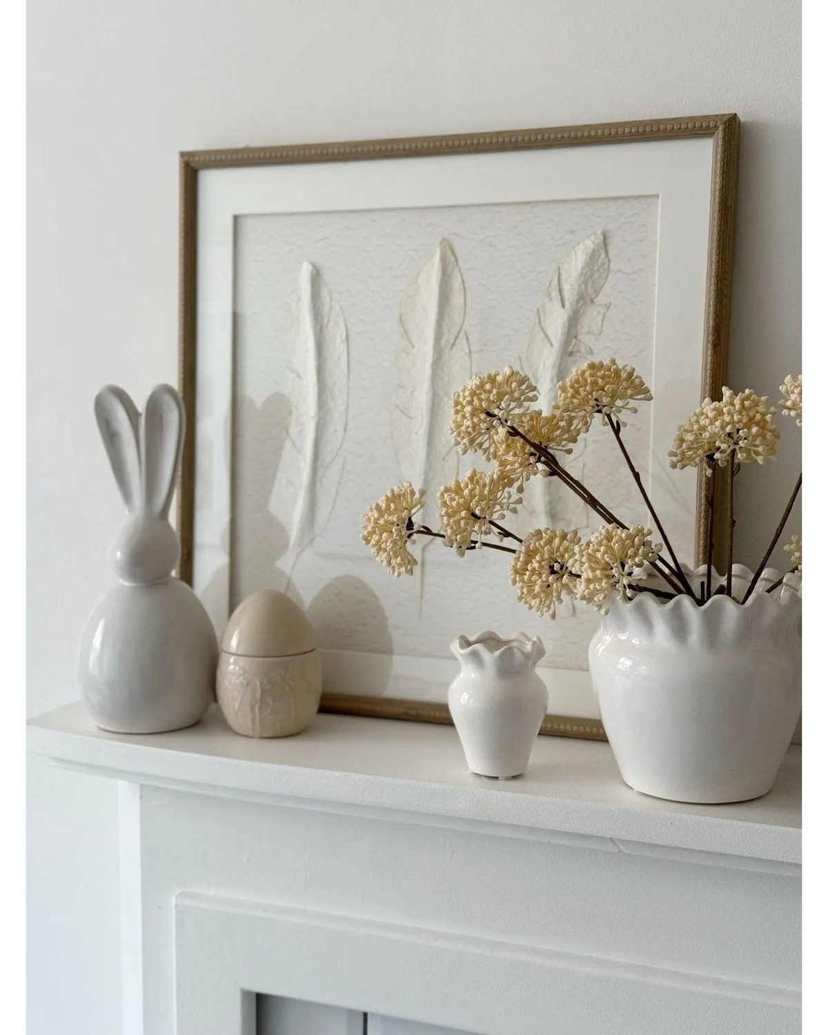 White feather wall art by Hill Interiors in a frame, showcasing a delicate feather design for elegant home decor.