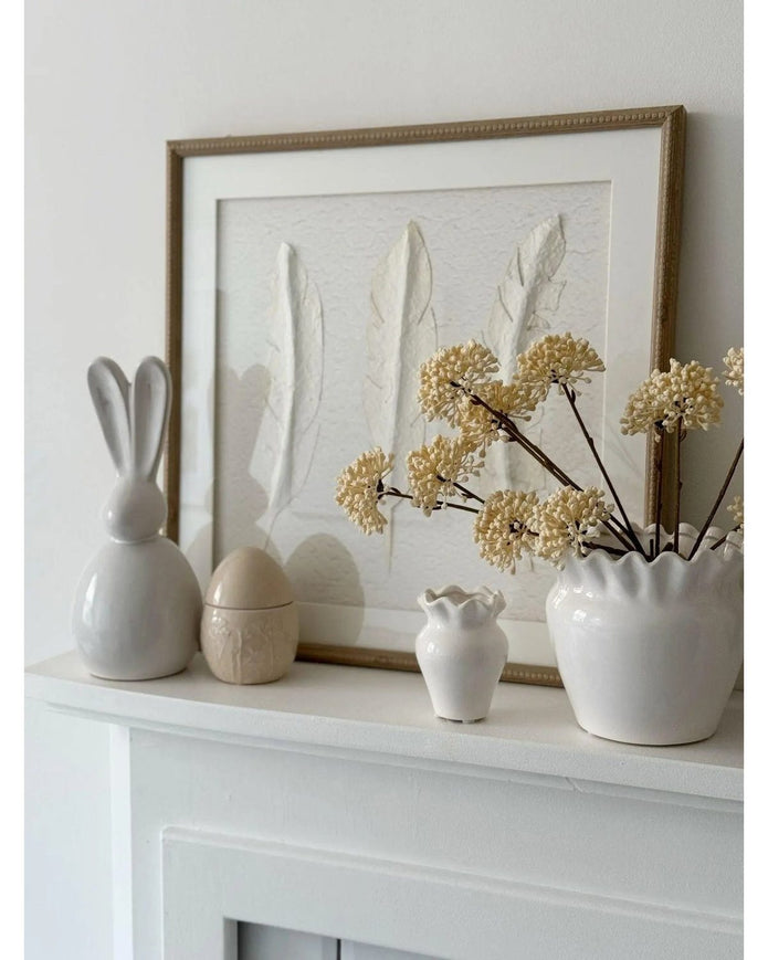 White feather wall art by Hill Interiors in a frame, showcasing a delicate feather design for elegant home decor.