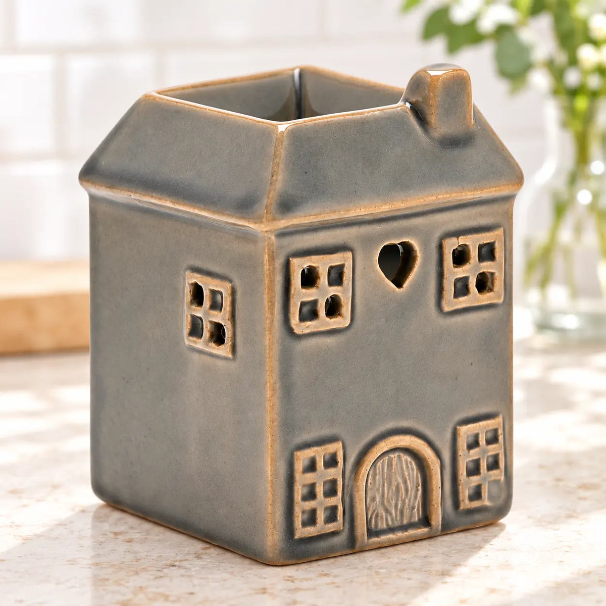Grey ceramic house shaped wax melt burner by Widdop & Co on a kitchen counter