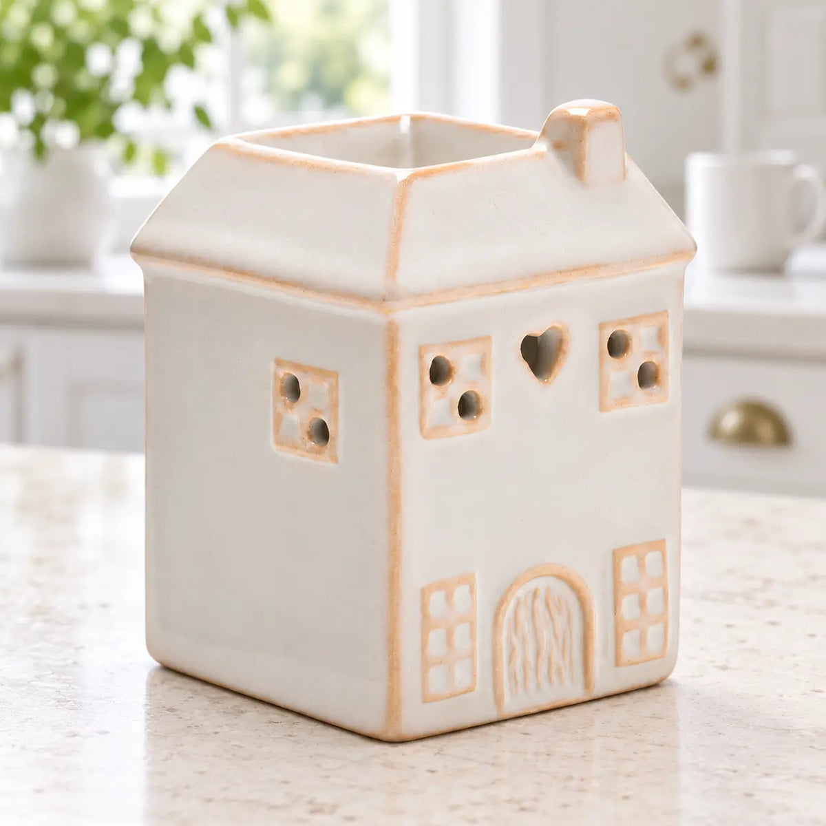 White ceramic house-shaped wax melt burner by Widdop & Co in a spring kitchen setting