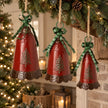 Set of three large red metal Christmas bells with green bows and pine tree detailing hanging from a festive mantel garland