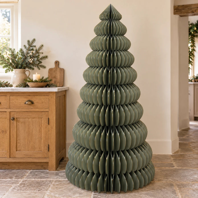 Large green Satchville paper Christmas tree standing upright, lifesize holiday decoration for festive home decor.