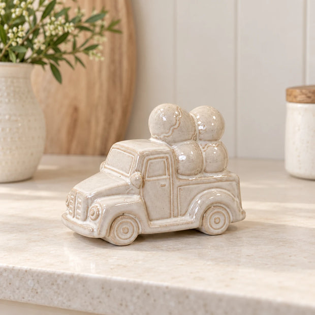 Ivory and stone-toned glazed ceramic car carrying decorative eggs, styled kitchen view, 13cm wide.