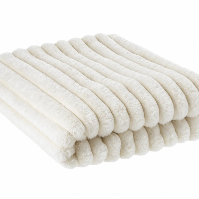 Close-up of the ivory throw's fluffy faux fur fibres and raised ribbed texture