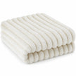 Folded ivory white ribbed faux fur throw blanket on a white studio background
