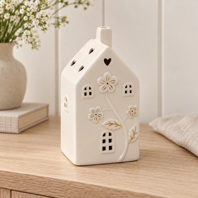 Large 17cm ivory ceramic LED house with raised flowers and gold-coloured details, console view, LED switched off.
