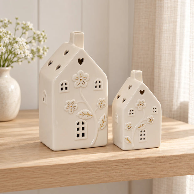 Pair of small ivory ceramic houses with LED lights and floral details, perfect for home decor by Satchville.