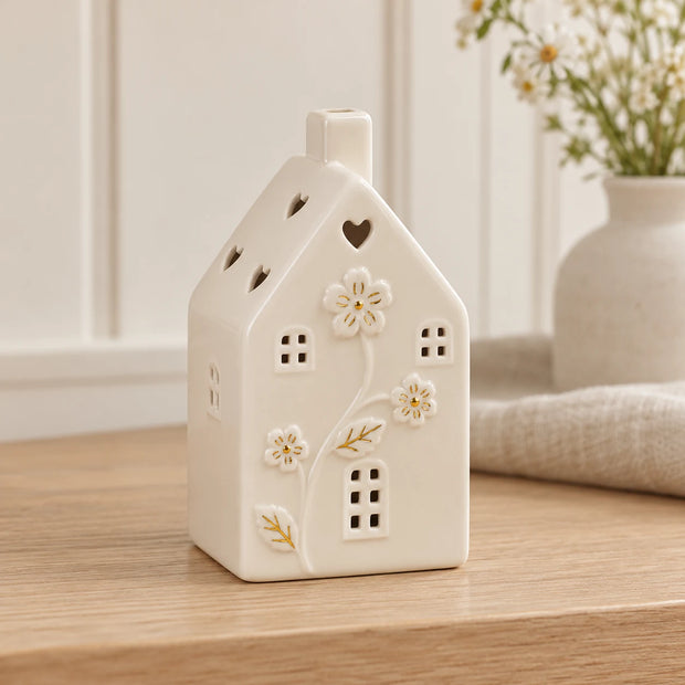 Small ivory ceramic house with floral details and LED light, decorative home decor piece by Satchville.