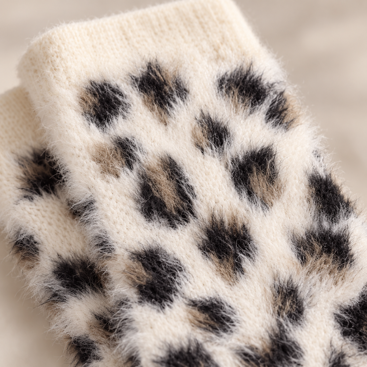 Close-up of cream black and tan fluffy leopard knit