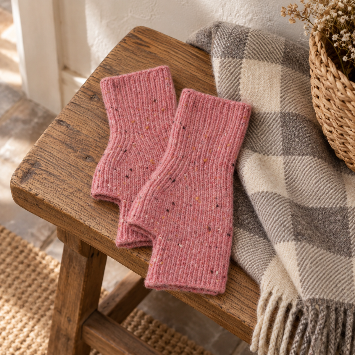 Pink speckle fingerless gloves on a rustic wooden bench