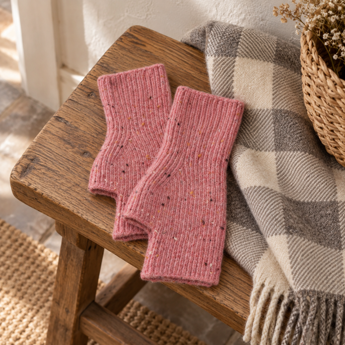 Pink speckle fingerless gloves on a rustic wooden bench