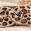 Close-up of the fluffy tan cream and black leopard headband knit