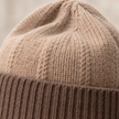 Close-up of oatmeal crown and cappuccino rib cuff knit