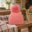 Pink speckle bobble hat in a warm country-home setting