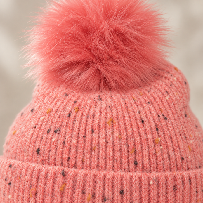 Close-up of pink speckled rib knit and fluffy pom-pom