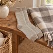 Oatmeal marl cosy socks on a rustic country bench