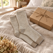 Oatmeal marl cosy socks styled beside a kraft gift box