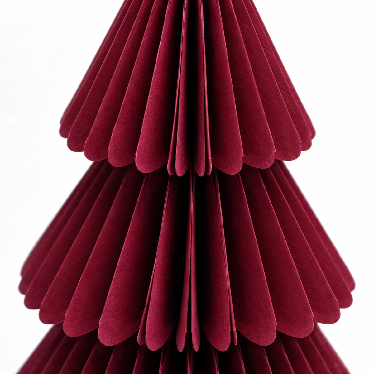 Close-up of burgundy paper folds and scalloped tier edges.
